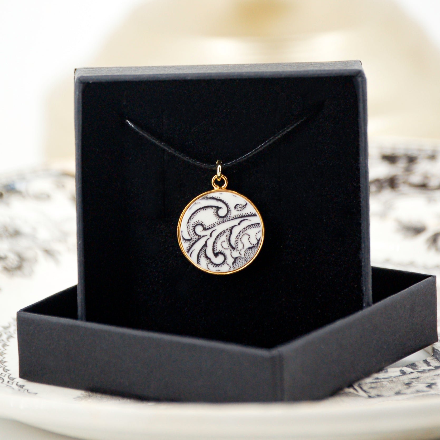 Pendant "Flowers and scrolls in black and white", gold finish